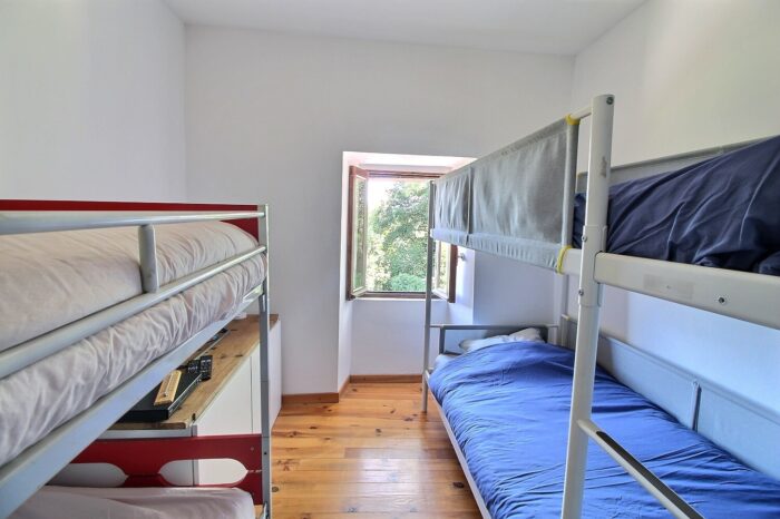 Chambre avec deux lits doubles superposés, un bleu et un rouge
