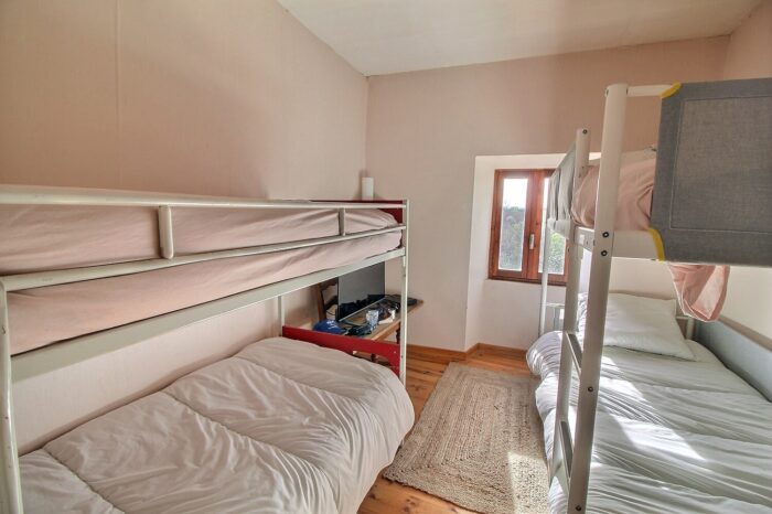 Chambre avec deux lits doubles superposés, un bleu et un rouge
