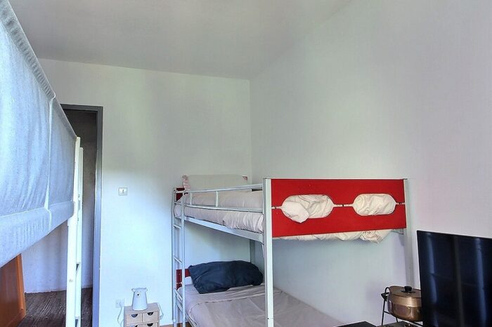 Chambre avec deux lits doubles superposés, un bleu et un rouge