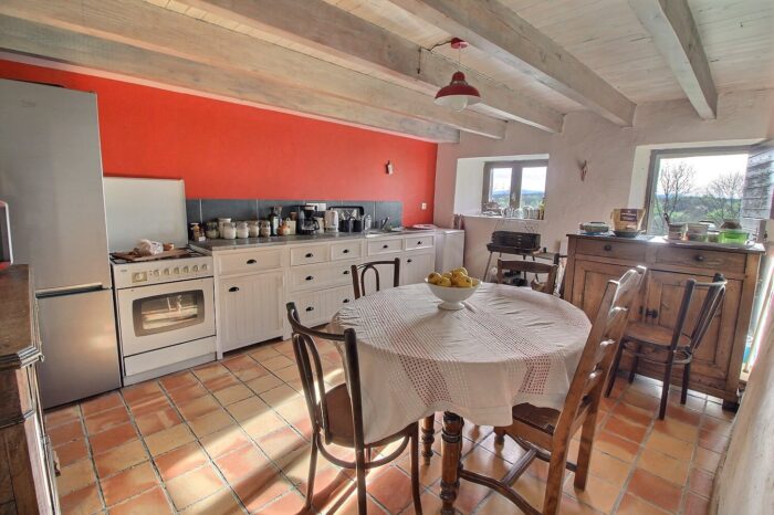 Cuisine équipée rouge avec une petite table ronde centrale
