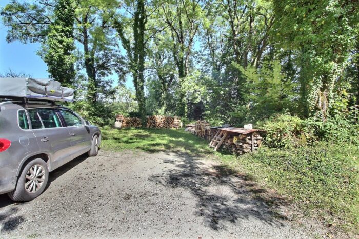 Parking en terre près de piles de bois