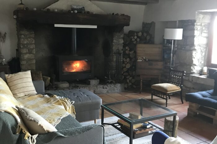 Vue sur la table basse et le poêle à bois allumé
