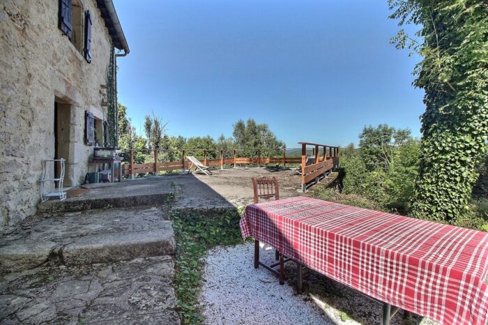 Terrasse de la bergerie avec grande table nappée et des transats